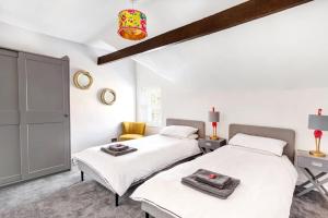 - 2 lits dans une chambre aux murs blancs dans l'établissement Stunning 4Bed Townhouse by HIC & Trendy Kings Quarter!, à Harrogate