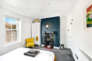 - une chambre avec un lit, une chaise et une cheminée dans l'établissement Stunning 4Bed Townhouse by HIC & Trendy Kings Quarter!, à Harrogate