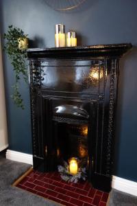- une cheminée noire avec bougies dans la chambre dans l'établissement Stunning 4Bed Townhouse by HIC & Trendy Kings Quarter!, à Harrogate