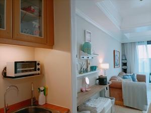 a kitchen with a sink and a living room at Niwill Homestay in Taichung