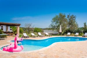 a child is playing in a pool with a pink inflatable at CAN FARITZEO in Sant Rafael de Sa Creu
