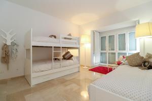 sypialnia z 2 łóżkami piętrowymi i kanapą w obiekcie Family apartment with garden- Los Monteros Palm Beach w Marbelli +37 zdjęć