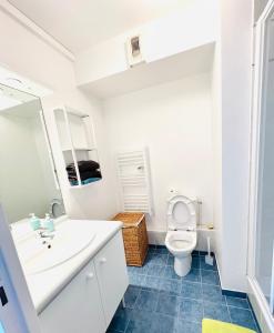 a white bathroom with a toilet and a sink at Experience olympique proche Paris in Le Plessis-Robinson