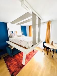 una camera con letto, scrivania e tavolo di Experience olympique proche Paris a Le Plessis-Robinson