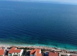 an aerial view of the ocean and houses on the shore at Apartments Blueness in Prigradica