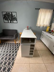 a small kitchen with a white counter and a table at Apartamento el uno in Chuy