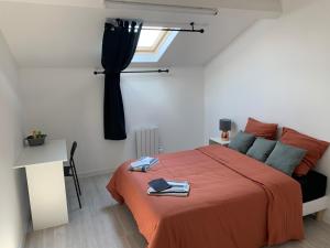 a bedroom with a bed and a desk and a window at Villa Tenjin Chambre 1 in Bondy