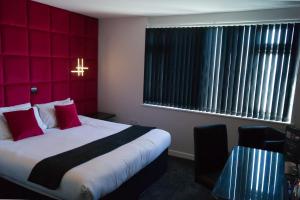 una camera d'albergo con letto e parete rossa di The Bromley a Blackpool