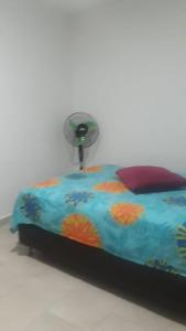 uma cama com um edredão colorido e uma ventoinha em Apartamento completo medellin em Medellín