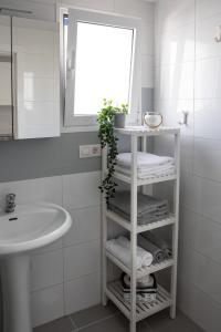 a bathroom with a sink and a shelf with towels at Ocean apartment in Tías