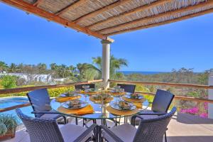 a table and chairs on a patio with a view of the ocean at Lavish Cabo Resort Retreat with Pool Near the Beach! in Cabo San Lucas