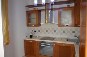 a kitchen with wooden cabinets and a sink at Il Girasole del Centro Storico in Alcamo