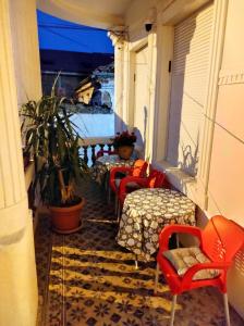 uma varanda com cadeiras, mesas e uma mesa em Guest House Prilep em Prilepo