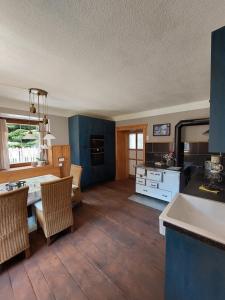 雷恩維格的住宿－Haus Zurrik，厨房配有蓝色橱柜和桌椅