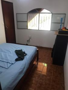 a bedroom with a bed with a green shirt on it at Tabarka Lodge in Nova Friburgo