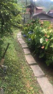 a path in a garden with flowers and plants at Tabarka Lodge in Nova Friburgo