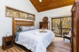 a bedroom with a large bed and a window at 7th Hole Chalet at Wintergreen Resort Hot Tub, Sauna & 3 Fireplaces in Wintergreen +27 photos