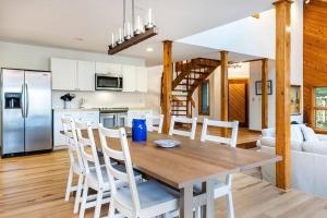 a kitchen and living room with a wooden table and chairs at 7th Hole Chalet at Wintergreen Resort Hot Tub, Sauna & 3 Fireplaces in Wintergreen