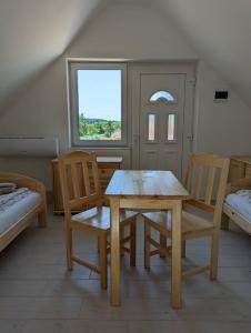 ein Esszimmer mit einem Tisch, Stühlen und einem Fenster in der Unterkunft Fazekas Vendégház in Balatonkeresztúr