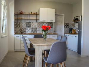 a kitchen with a table with a vase of flowers on it at Apartmani Nana Mija in Pag