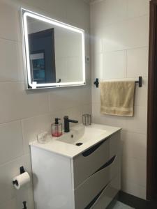 a white bathroom with a sink and a mirror at Sweet Home in Ponta Delgada +4 photos