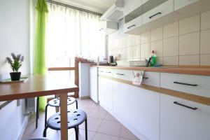 a kitchen with white cabinets and a table and chairs at Willa u Perełki in Zakopane