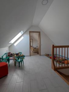 een zolderkamer met een tafel en stoelen en een slaapkamer bij Fazekas Vendégház in Balatonkeresztúr