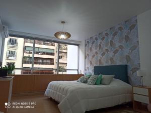 um quarto com uma cama e uma grande janela em Recoleta Beatiful Gran Callao Concord em Buenos Aires