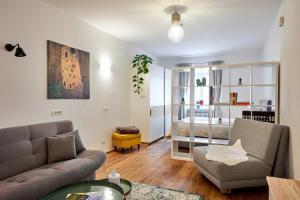 una sala de estar con un sofá y una silla en KARINA Lauben Lodge, en Egna