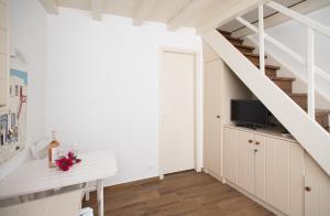 a white staircase with a tv in a room at Myconian Old Town Maisonette THE MIMIs PLACE in Mýkonos City