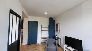 ルルドにあるEscapade à Lourdes dans T2 Bis proche Gare et Centre villeのリビングルーム(椅子、テレビ付)