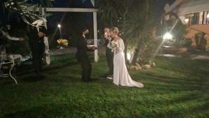 a bride and groom are standing in the grass at Villa Francesca Pomezia Roma in Pomezia