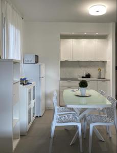 a kitchen with a table and chairs in a kitchen at MARICAMPO Monolocale con piscina e parcheggio in Marina di Campo