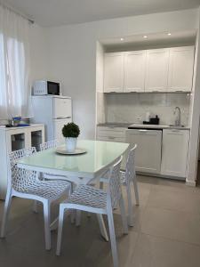 a kitchen with a table and chairs and a kitchen with white cabinets at MARICAMPO Monolocale con piscina e parcheggio in Marina di Campo