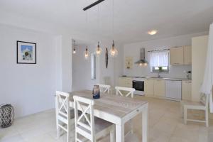 a kitchen and dining room with a table and chairs at White House with Sea View in Ambelas