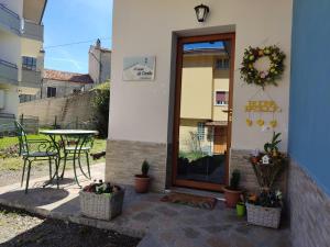 un patio con tavolo, sedie e porta in vetro di B&B A casa di Carla a Castelsaraceno