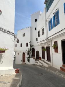 een steegje met witte gebouwen op een straat bij La Tour de L'air in Tanger