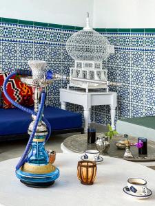 a living room with blue and white walls and a table at Dar Colibri - Maison d'hôtes à Kélibia in Kelibia