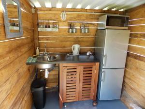 uma pequena cozinha com um lavatório e um frigorífico em Camping du Petit Gué du Roi em Cléry-Saint-André
