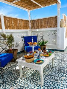 una mesa con comida en la parte superior de un patio en Dar Colibri - Maison d'hôtes à Kélibia en Kelibia