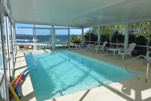 a swimming pool in a house with a view of the ocean at Apart Hotel Terrazas de San Francisco in Piriápolis