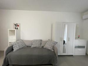 a living room with a couch with pillows on it at MARICAMPO Monolocale con piscina e parcheggio in Marina di Campo +19 photos
