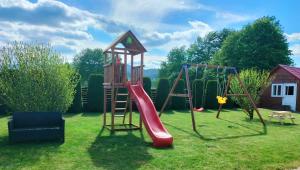 Pensiunea Miorița Putna في بوتنا: ملعب مع زحليقة حمراء وسلم