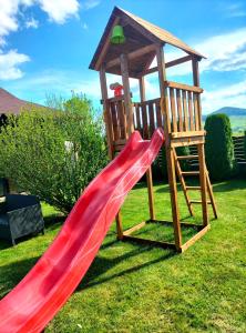 Pensiunea Miorița Putna في بوتنا: شريحة حمراء وشرفة خشبية