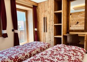 a bedroom with a bed and a desk and a window at Chalet Nano in Livigno