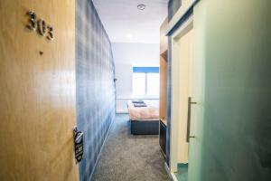 przedpokój z drzwiami i łóżkiem w pokoju w obiekcie Apartment Chinatown 303 w mieście Newcastle upon Tyne