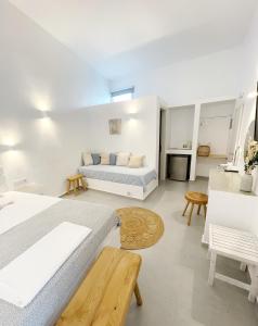 biały pokój z dwoma łóżkami i kanapą w obiekcie Kirki Rooms by the sea w mieście Parikia