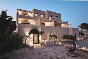 - un grand bâtiment blanc avec une terrasse en face dans l'établissement Noma Milos - Delmar Collection, à Provatas