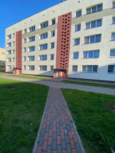 a brick walkway in front of a building at Siguldas apartment in Liepāja