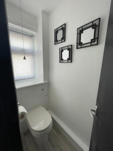 uma casa de banho com WC e três espelhos na parede em Romney Sands Holiday Apartment em New Romney